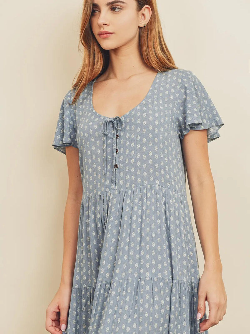 Woman wearing a blue polka dot dress against a beige background