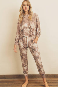 Woman wearing a tie-dye lounge set against a plain background