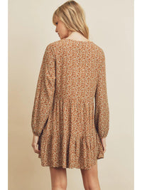 Woman wearing a floral dress with long sleeves on a beige background