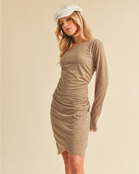 Woman wearing a brown long-sleeve dress against a beige background