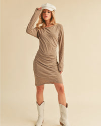Woman wearing a brown dress and white cowboy boots on a beige background