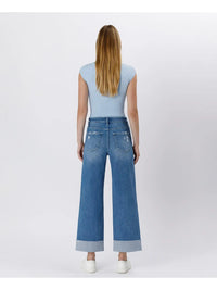 Person wearing blue jeans and a light blue top on a white background