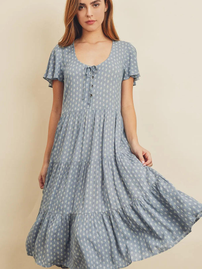 Woman wearing a blue polka dot dress against a beige background
