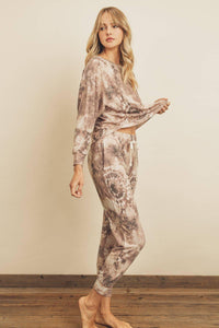 Woman wearing a patterned loungewear set against a plain background