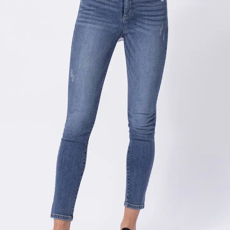 Model wearing Sneak Peek high-rise skinny jeans with light distressing, styled with a white tank.