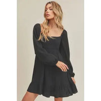 Woman wearing a black dress against a neutral background