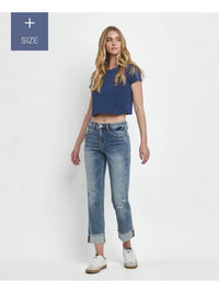 Woman wearing a blue crop top and light blue jeans on a white background