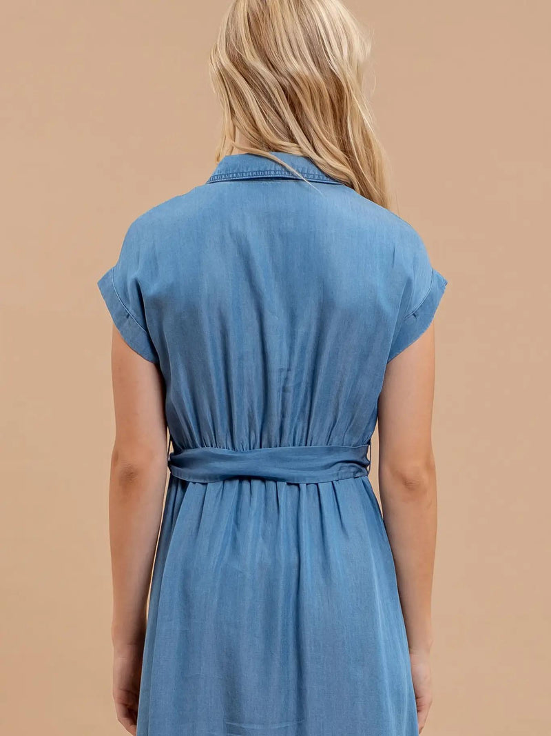 Woman wearing a blue dress against a beige background