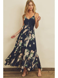 Woman wearing a navy floral maxi dress against a plain background